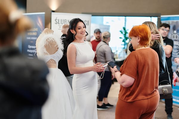 Modelka w sukni ślubnej wśród odwiedzających